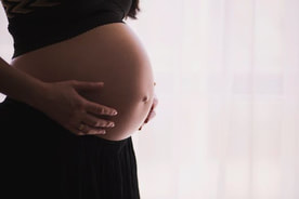 Expecting mother cradling her pregnant belly